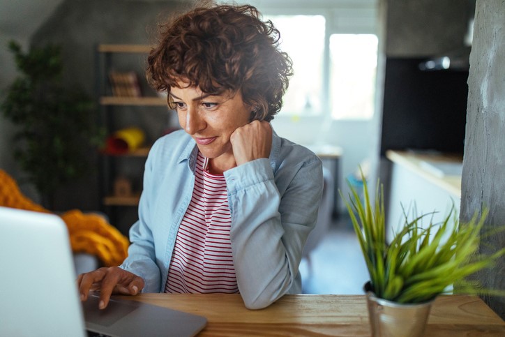 Woman reading website content on laptop.